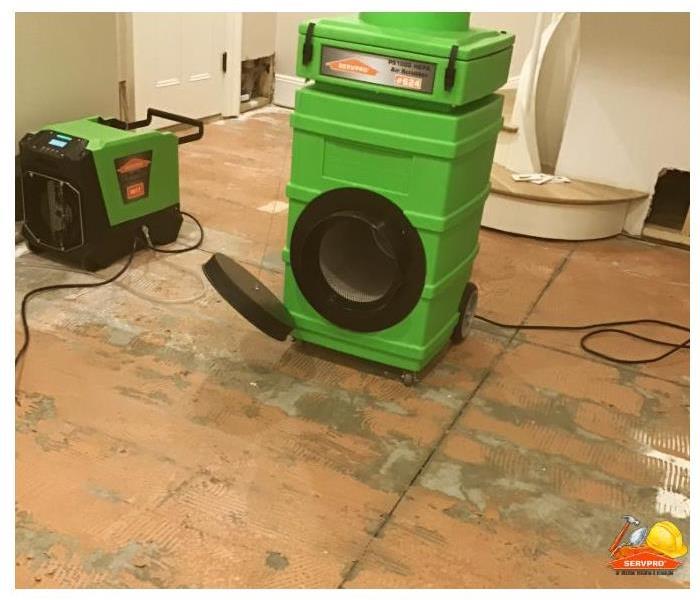 dehumidifier and air mover placed in room to dry floor after hardwood is removed from subfloor